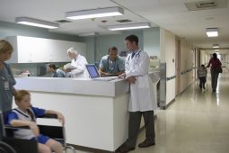 Doctors and patient on wheelchair in hospital corridor