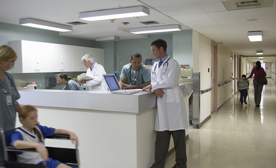 Doctors and patient on wheelchair in hospital corridor