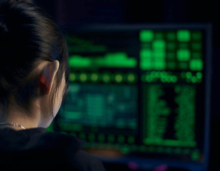 Person looking at a screen filled with green code.