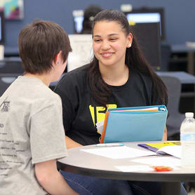 Two students conversing at a table