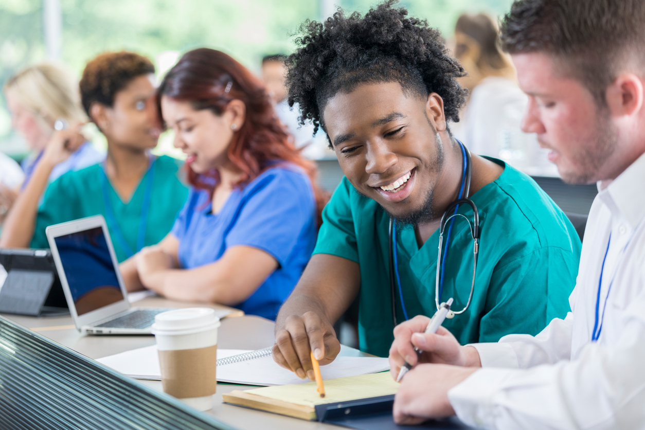 Diverse male medical students work together on project