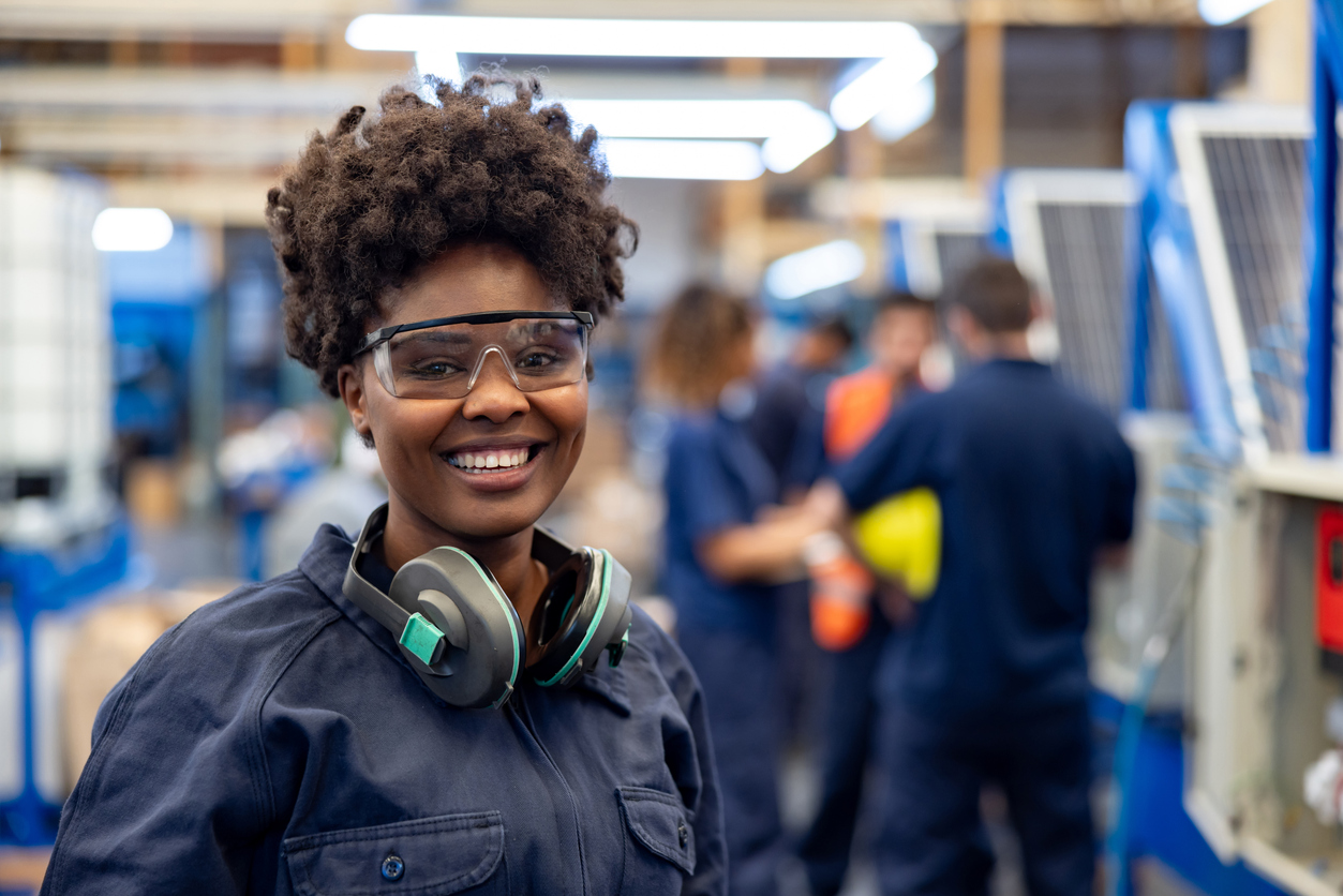 Happy employee working at a solar panel factory