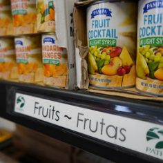 Colorful assortment of fruits and vegetables neatly arranged on shelves in a grocery store.