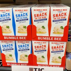 Bumble bee snack boxes arranged on display shelves in a store, showcasing various flavors and packaging designs.
