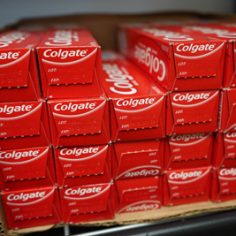 A stack of Colgate toothpaste on a shelf